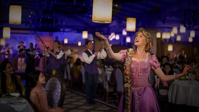 Rapunzel gazes in wonder at one of many hanging lanterns in a restaurant